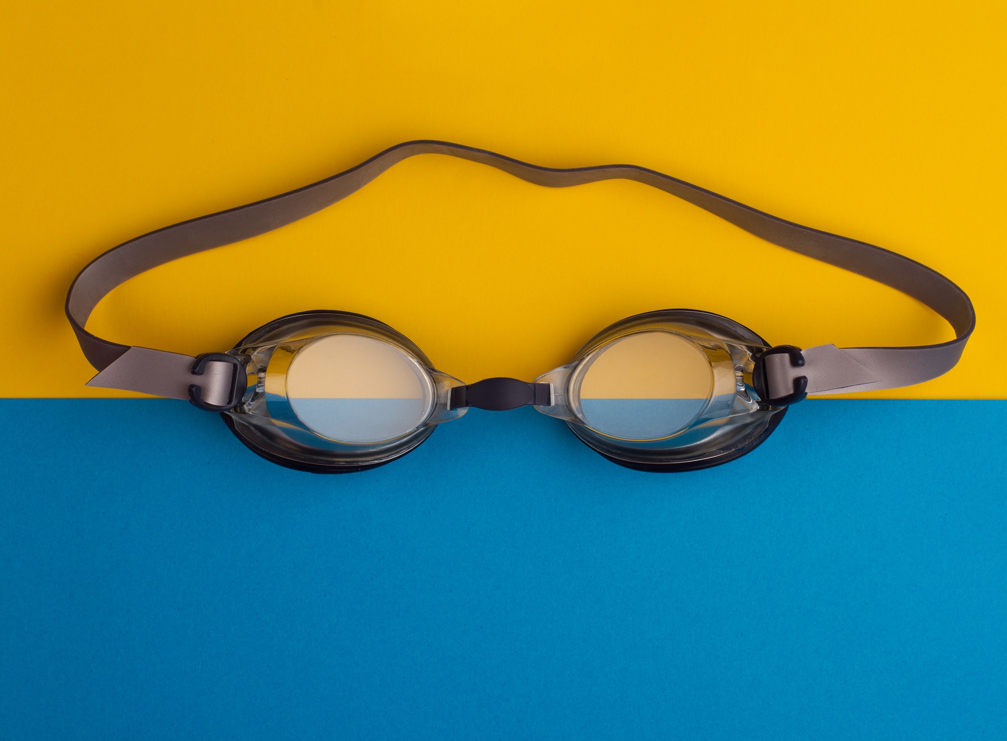swimming goggles on blue and yellow background